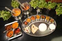 Hotel Ambicas Grand في فيساخاباتنام: طاولة مع صينية من الطعام على طاولة