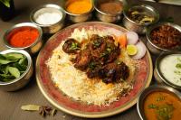 Hotel Ambicas Grand في فيساخاباتنام: طبق من الطعام مع الرز واللحوم على الطاولة