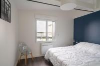 a bedroom with a bed and a chair and a window at Appartement vue mer a lIle Tudy in Île-Tudy