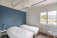 two beds in a room with a blue wall at Appartement vue mer a lIle Tudy in Île-Tudy