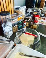 un piano di lavoro con molti contenitori di cibo sopra di Pousada solar do Cerrado a Rifaina