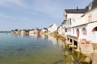 a view of a river with buildings and houses at Appartement vue mer a lIle Tudy in Île-Tudy