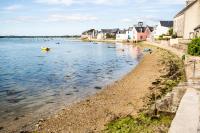 a beach with houses and boats in the water at Appartement vue mer a lIle Tudy in Île-Tudy