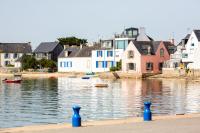 a body of water with houses and boats in it at Appartement vue mer a lIle Tudy in Île-Tudy