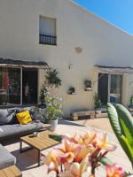 a patio with a couch and a table with flowers at Villa Manoe in Draguignan