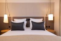 a bedroom with a bed with two pillows and two lights at Hôtel Toujours &amp; Spa in Paris