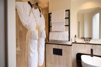 a bathroom with a sink and towels hanging on a wall at Hôtel Toujours &amp; Spa in Paris