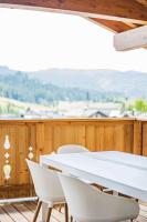 a white table and chairs on a wooden deck at Dachstein West Apartment T4 in Russbach am Pass Gschütt