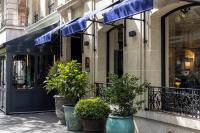 a store front with blue awnings and potted plants on a sidewalk at Hôtel Toujours &amp; Spa in Paris