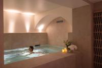 a woman in a hot tub in a room at Hôtel Toujours &amp; Spa in Paris