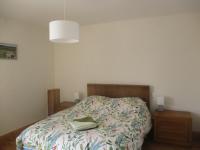 a bedroom with a bed and a lamp at Appartement La petite Résie in La Résie-Saint-Martin
