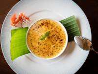 a white plate with a bowl of soup on a table at Le Taha'a by Pearl Resorts in Motu Tautau