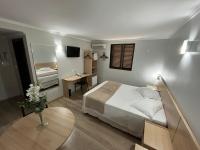 Una habitación de hotel con una cama y una mesa con escritorio. en Hotel Ijuí, en Ijuí