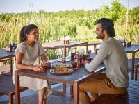 a man and a woman sitting at a picnic table at Life At REPOSE- Lake Villas Resort & Club in Chor Warodra