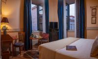 a hotel room with a bed and a table and chairs at The Pucic Palace in Dubrovnik