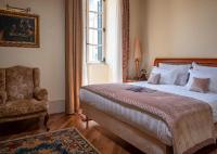 a bedroom with a bed and a chair and a window at The Pucic Palace in Dubrovnik