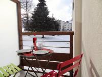 a table and chairs on a balcony with a christmas tree at Appartement Les Deux Alpes, 2 pièces, 4 personnes - FR-1-516-43 in Les Deux Alpes
