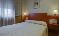 A bed or beds in a room at Hostal Forum