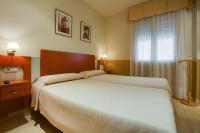 A bed or beds in a room at Hostal Forum