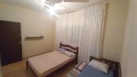 a small bedroom with two beds and a window at Residência Manto Azul in Aparecida
