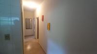 a hallway with a white wall with a light at Residência Manto Azul in Aparecida