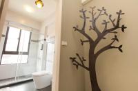 a bathroom with a tree stenciled on the wall at Happiness Homestay in Hualien City