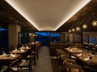 um restaurante com mesas, cadeiras e um bar em GOTO RETREAT by Onko Chishin em Goto