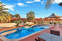 una piscina con mesa de picnic frente a un edificio en Comfort Inn Whyalla, en Whyalla