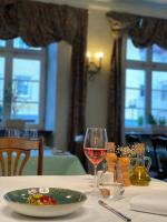 a table with a plate of food and a glass of wine at Hotel & Restaurant Zum Riesen in Walldürn