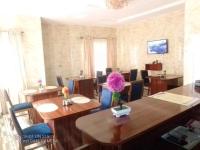 a dining room with wooden tables and blue chairs at Credence Resorts Aco in Ligwai
