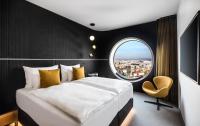 a bedroom with a large bed and a round window at MOOONS Vienna in Vienna
