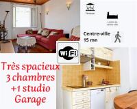 a kitchen and a living room with a red couch at Pavillon de 4 couchages, très calme, proche centre ville in Albi
