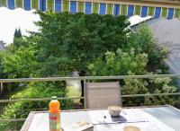 a table on a balcony with a view of trees at Pavillon de 4 couchages, très calme, proche centre ville in Albi