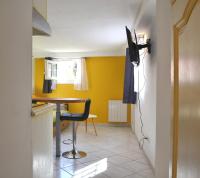a small kitchen with a table and a yellow wall at Pavillon de 4 couchages, très calme, proche centre ville in Albi