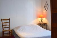 a bedroom with a bed and a chair and a lamp at Pavillon de 4 couchages, très calme, proche centre ville in Albi