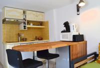 a kitchen with a wooden table with a microwave at Pavillon de 4 couchages, très calme, proche centre ville in Albi