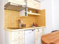 a kitchen with white cabinets and a sink and a table at Pavillon de 4 couchages, très calme, proche centre ville in Albi