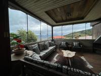ein Wohnzimmer mit Couch und großem Fenster in der Unterkunft Eco Mirante Hotel in Paulo Lopes