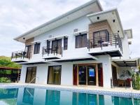 uma casa com uma piscina na frente em Casa De Española Hotel and Resort em Aritao