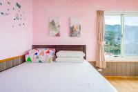 a bedroom with a bed with pink walls and a window at Jiufen Kite Museum in Jiufen