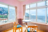 a room with a table and chairs and windows at Jiufen Kite Museum in Jiufen