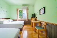 a room with two beds and a desk and a window at Jiufen Kite Museum in Jiufen