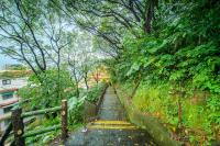 a stairway leading up a hill with trees at Jiufen Kite Museum in Jiufen