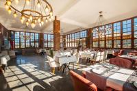 a restaurant with tables and chairs and a chandelier at Zanike hotel in Trabzon