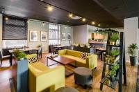 ein Restaurant mit gelben Sofas und Tischen in der Unterkunft Hotel IOR in Posen