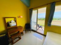 a bedroom with a bed and a mirror and a window at Kenting COMIC B&amp;B in Hengchun South Gate