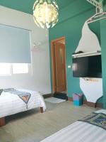 a room with two beds and a flat screen tv at Home in Hengchun Homestay in Hengchun South Gate