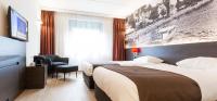 a hotel room with two beds and a television at Bastion Hotel Breda in Breda