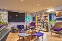 a waiting room with purple chairs and a flat screen tv at Campanile Lyon Centre - Berges du Rhône in Lyon
