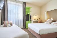 a hotel room with two beds and a green shelf at Campanile Lyon Centre - Berges du Rhône in Lyon